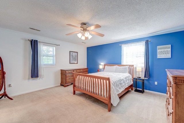 bedroom featuring ceiling fan, light colored carpet, a textured ceiling, and ornamental molding