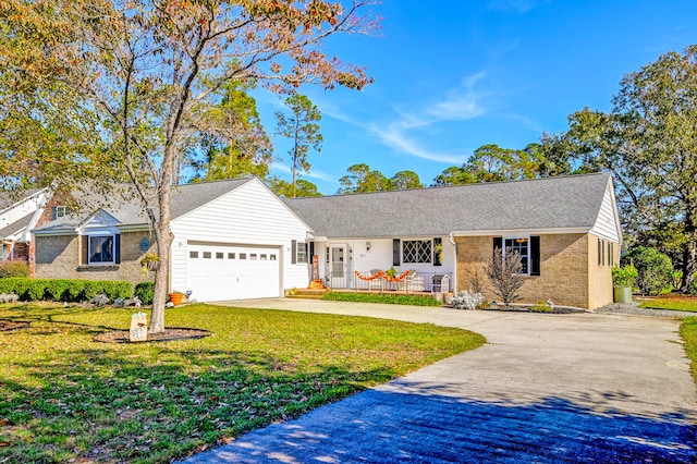 ranch-style house with covered porch, a garage, and a front lawn