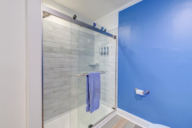 bathroom featuring hardwood / wood-style flooring, toilet, and a shower with shower door