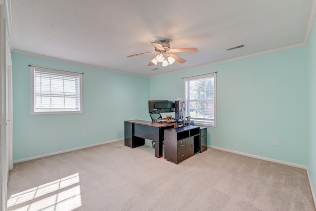 carpeted home office with ceiling fan, a healthy amount of sunlight, and ornamental molding