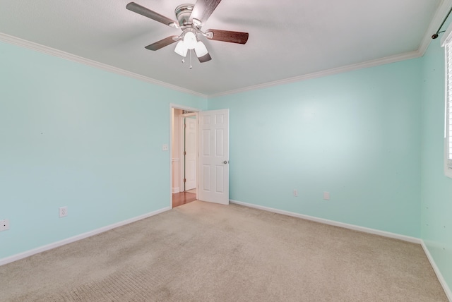 carpeted empty room with ceiling fan and crown molding