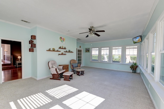 sitting room with ceiling fan, ornamental molding, and carpet floors