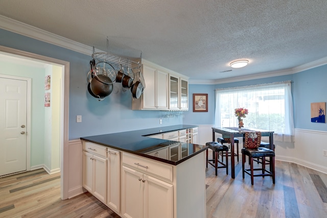 kitchen featuring light hardwood / wood-style flooring, white cabinets, and ornamental molding