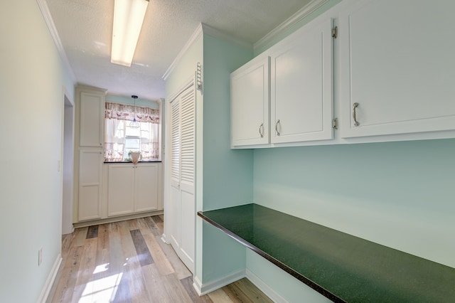 interior space with light hardwood / wood-style flooring, a textured ceiling, and ornamental molding