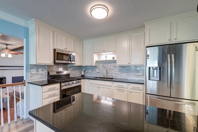 kitchen featuring dark stone counters, white cabinetry, and stainless steel appliances