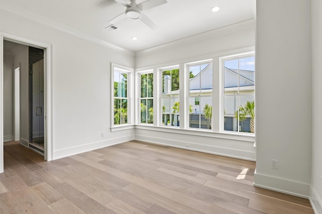 empty room with crown molding, ceiling fan, and light hardwood / wood-style floors