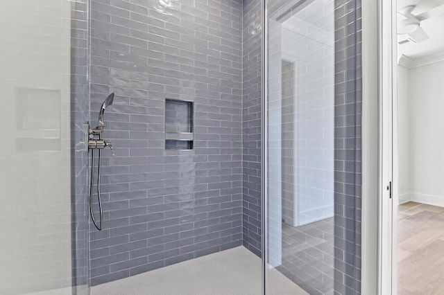 bathroom featuring crown molding and a tile shower