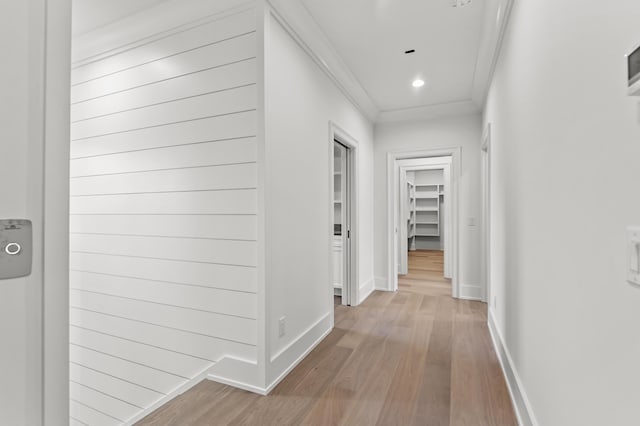 corridor featuring crown molding and light hardwood / wood-style flooring