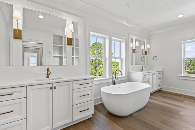 bathroom featuring crown molding, wood-type flooring, a bath, and vanity