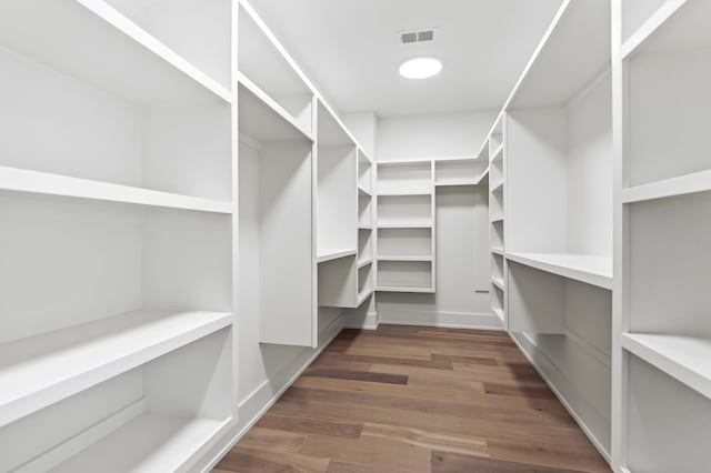 walk in closet with dark hardwood / wood-style flooring