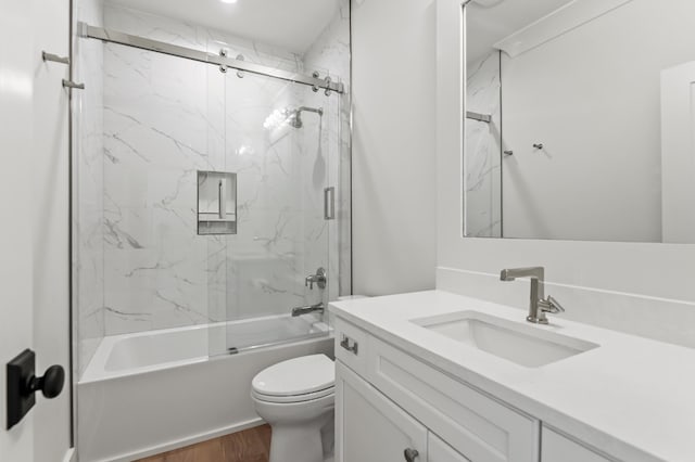 full bathroom featuring vanity, toilet, combined bath / shower with glass door, and hardwood / wood-style floors