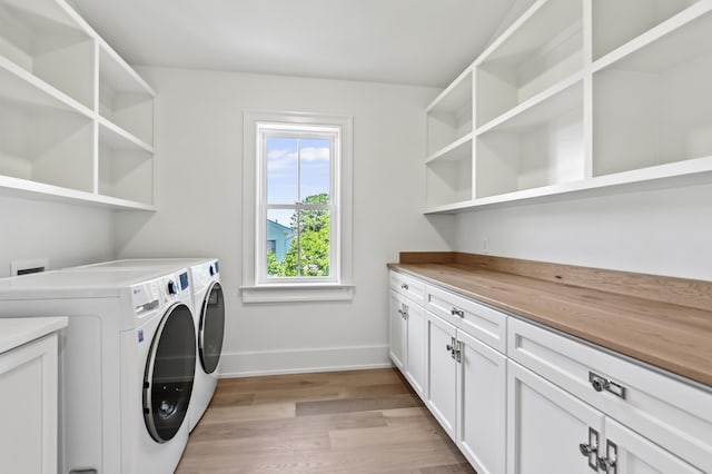 laundry area featuring cabinets, light hardwood / wood-style floors, and washer and dryer