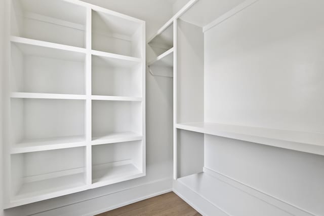 spacious closet with dark hardwood / wood-style flooring