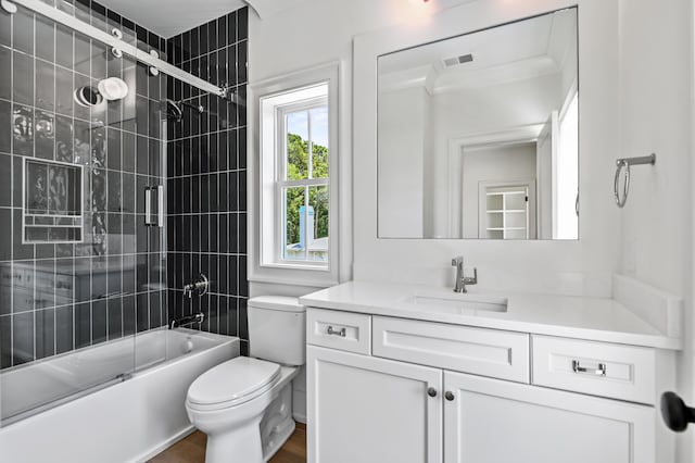 full bathroom with vanity, combined bath / shower with glass door, and toilet