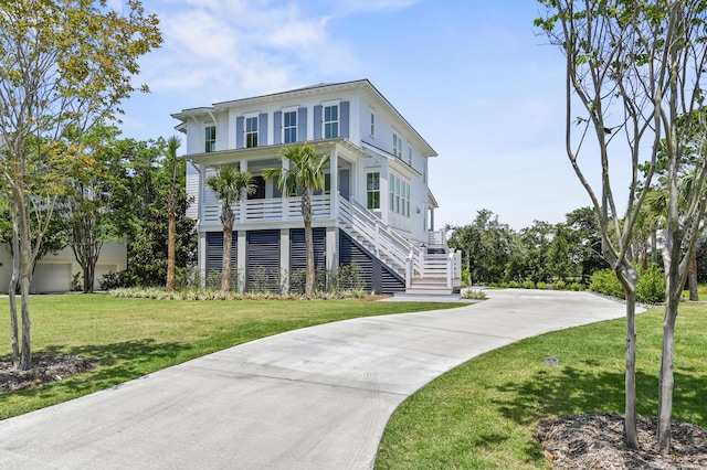 coastal inspired home featuring covered porch and a front lawn