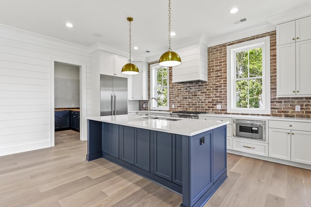 kitchen featuring white cabinetry, appliances with stainless steel finishes, sink, and decorative light fixtures