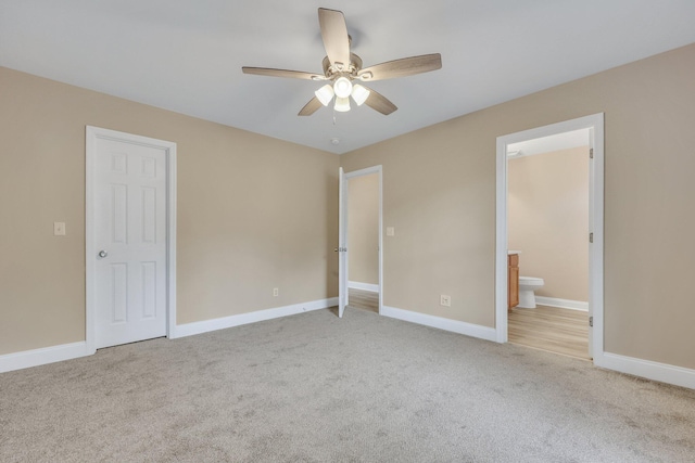 unfurnished bedroom with ceiling fan, light colored carpet, and connected bathroom