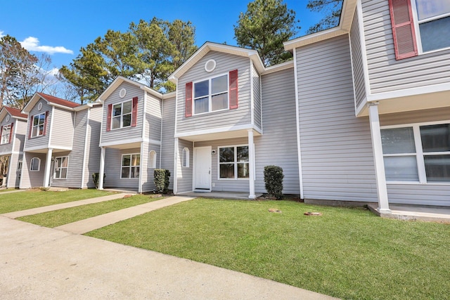 townhome / multi-family property featuring a front yard