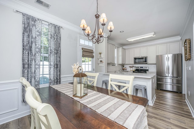 754 Certificate Ct, Charleston, SC 29414 - dining space featuring an inviting chandelier, wood finished floors, a wainscoted wall, visible vents, and ornamental molding