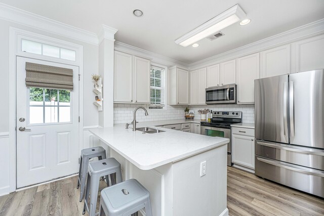 754 Certificate Ct, Charleston, SC 29414 - kitchen featuring a sink, a peninsula, stainless steel appliances, a breakfast bar area, and visible vents
