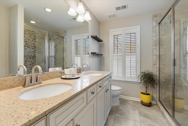 bathroom with tile patterned flooring, vanity, a shower with shower door, and toilet