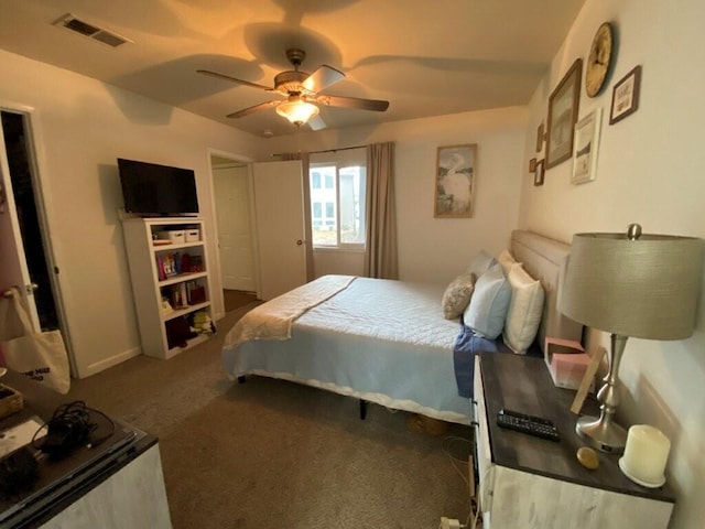 bedroom featuring visible vents, dark colored carpet, and ceiling fan
