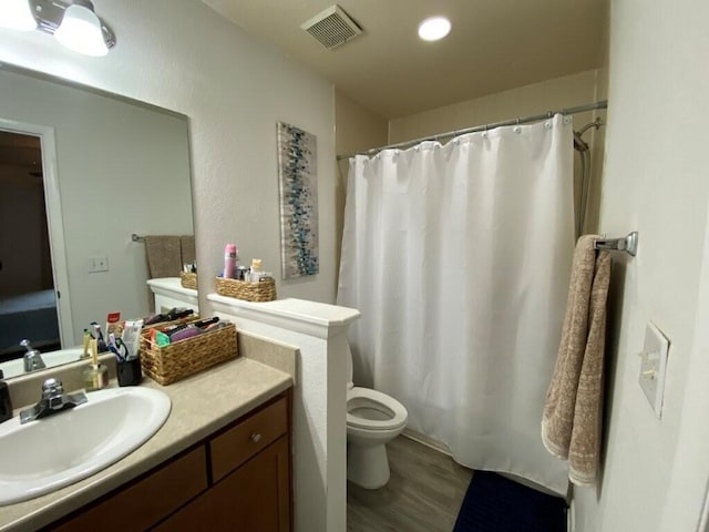 bathroom with vanity, wood finished floors, visible vents, curtained shower, and toilet