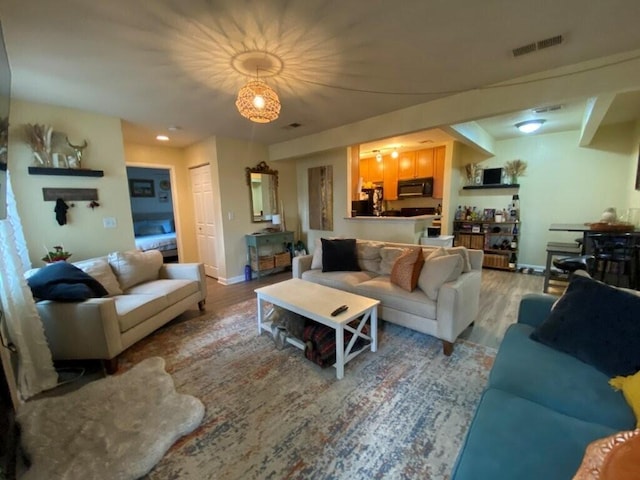 living area with visible vents, baseboards, and light wood-style floors