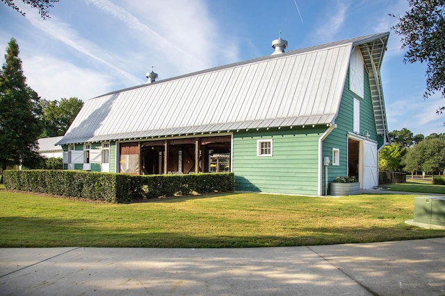 view of home's exterior with a yard, a gambrel roof, and metal roof