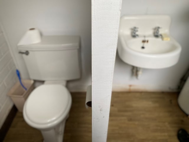 bathroom featuring hardwood / wood-style floors, toilet, and tile walls