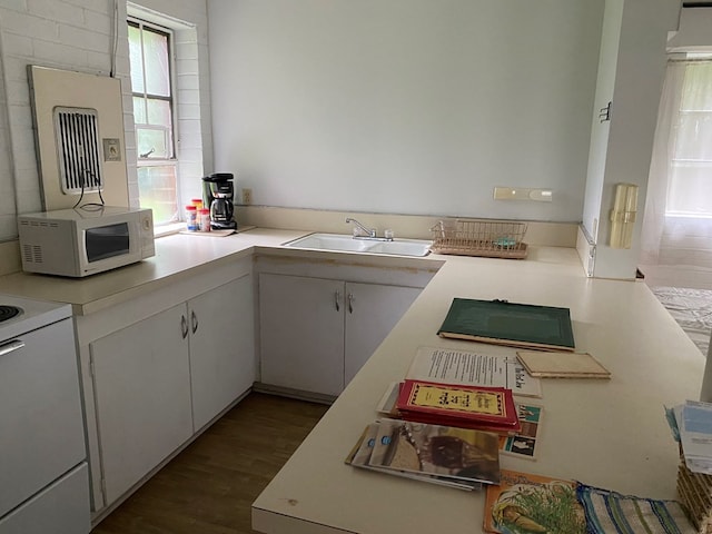 kitchen with hardwood / wood-style flooring, white appliances, sink, and white cabinets