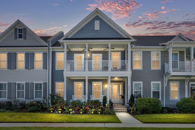 view of front of home with a yard and a balcony