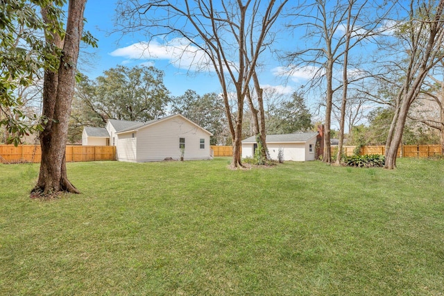 view of yard with an outbuilding, fence, and a detached garage