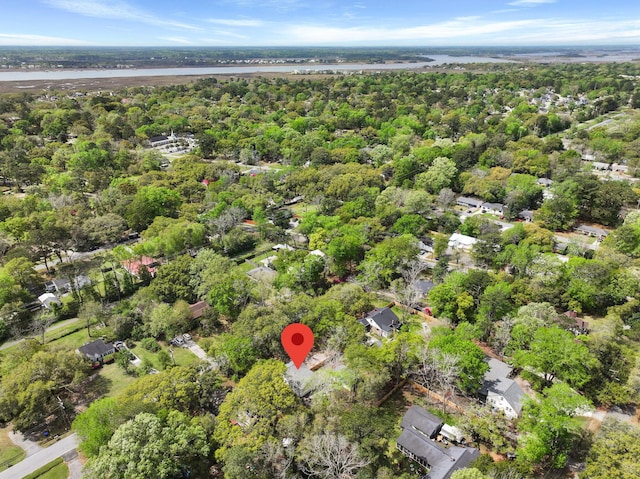 birds eye view of property featuring a water view and a wooded view
