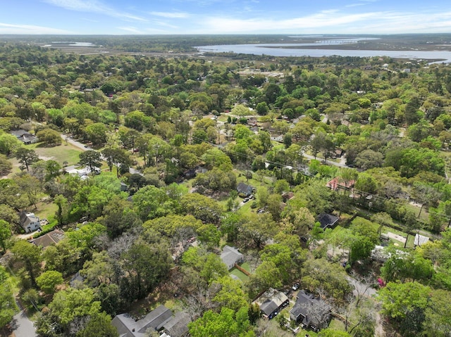 drone / aerial view with a wooded view and a water view