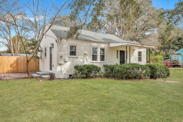 bungalow-style home with a shingled roof, crawl space, fence, and a front lawn