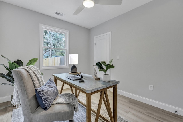 office area with baseboards, ceiling fan, visible vents, and light wood-type flooring