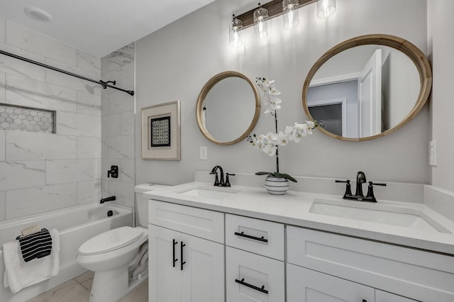 full bathroom featuring marble finish floor, double vanity, toilet, and a sink