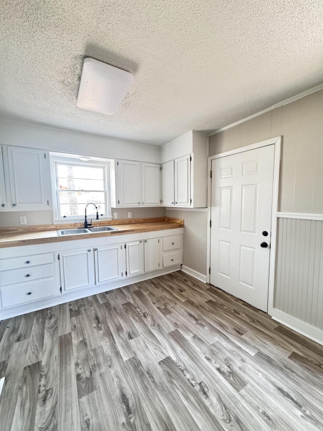 114 Madison St, Walterboro, SC 29488 - kitchen featuring light wood-type flooring, a textured ceiling, white cabinetry, and butcher block counters