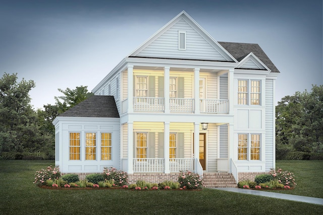 view of front of property featuring a balcony and a front yard