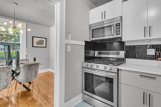 2215 Suffolk St, North Charleston, SC 29405 - kitchen featuring stainless steel appliances, light countertops, white cabinetry, a chandelier, and hanging light fixtures