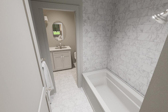 bathroom featuring toilet, vanity, and a washtub