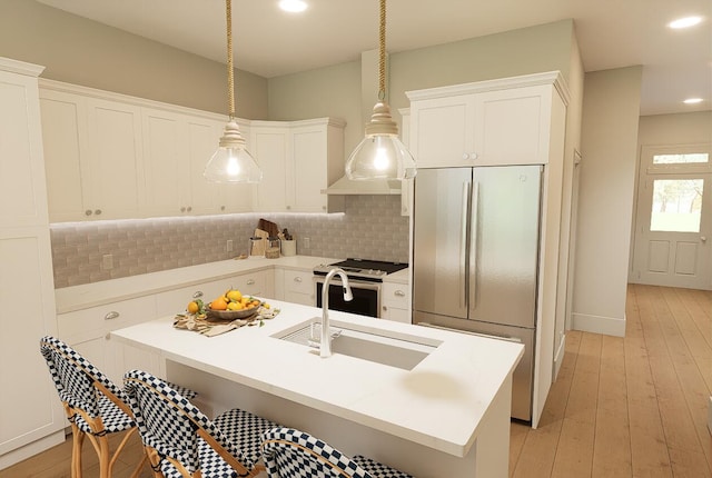 kitchen with tasteful backsplash, light wood-type flooring, white cabinetry, appliances with stainless steel finishes, and a sink