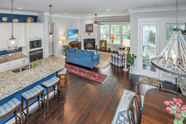 3769 Maidstone Dr, Mount Pleasant, SC 29466 - living area featuring a glass covered fireplace, ceiling fan, dark wood-style flooring, recessed lighting, and ornamental molding
