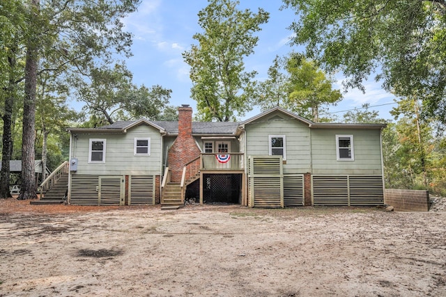 rear view of property featuring a wooden deck