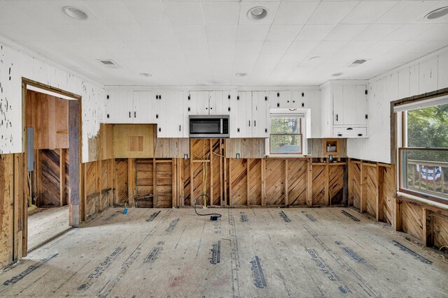 kitchen with white cabinets and wooden walls