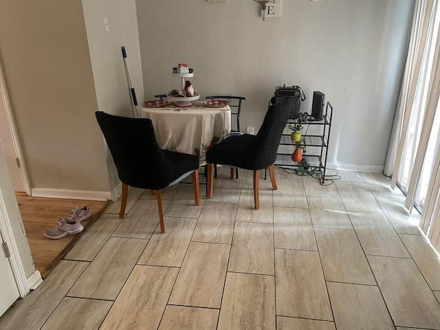 dining room featuring light wood-style flooring and baseboards