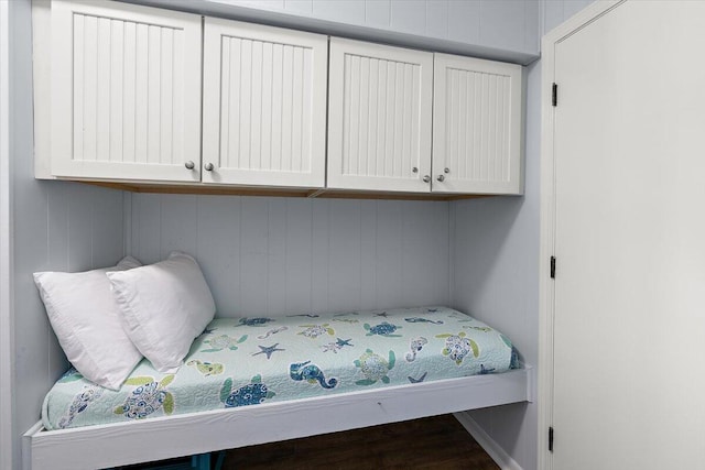 bedroom featuring wood walls and hardwood / wood-style floors