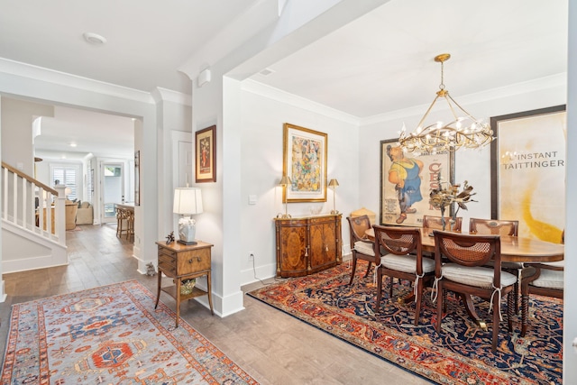 dining area with ornamental molding, a chandelier, and hardwood / wood-style flooring