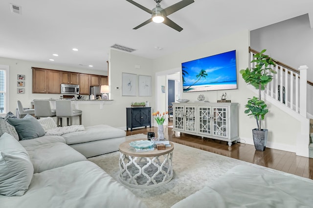 living area featuring stairs, recessed lighting, visible vents, and wood finished floors